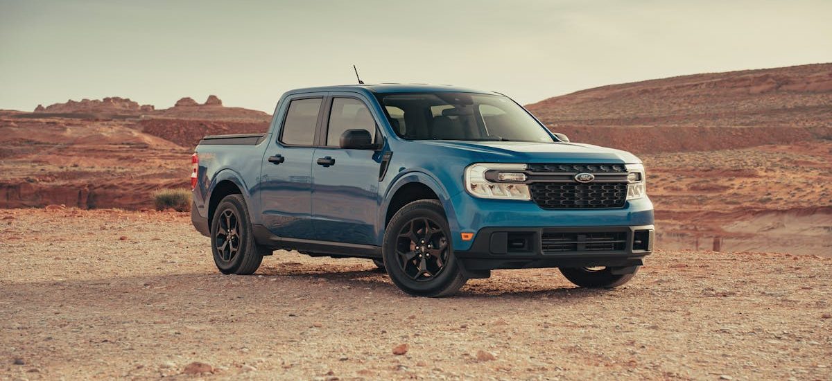A blue Ford Maverick pickup truck in a serene desert landscape near Page, Arizona.